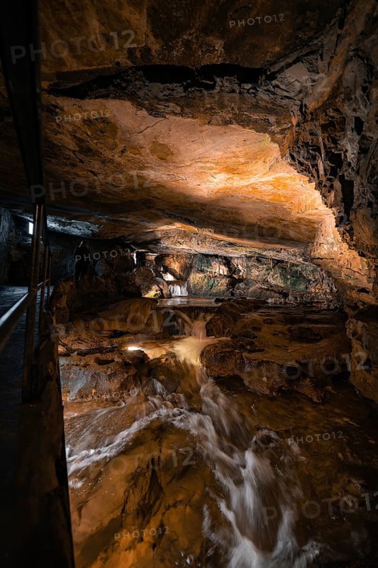 Rushing watercourse in a hilly cave environment, illuminated, adventurous, Beatus Caves, Switzerland