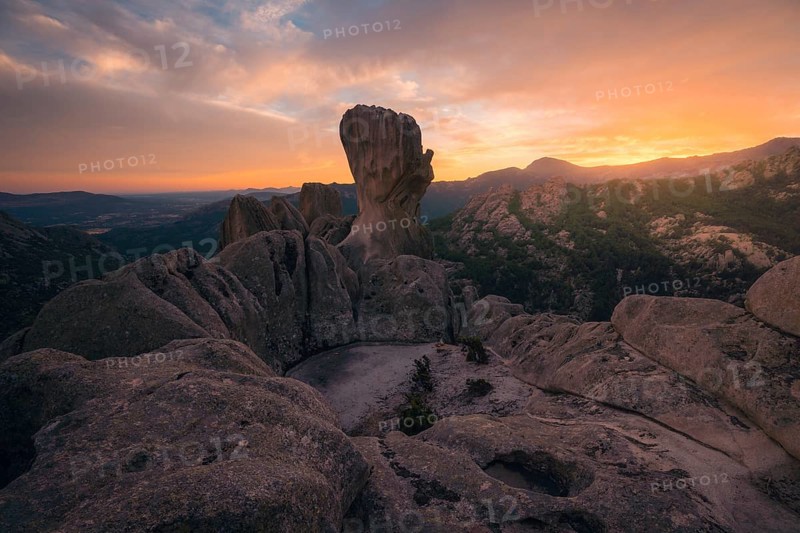 Captivating sunset view over the dramatic rock formations in Pedriza, Madrid. The warm hues paint the sky, highlighting the rugged beauty of the Sierra de Guadarrama landscape
