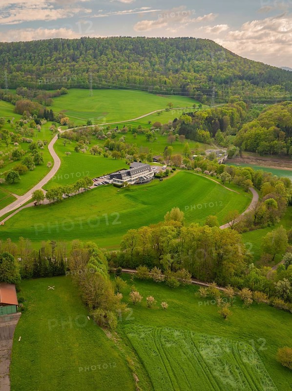 Hotel in the middle of a green hilly landscape with surrounding fields, Glems reservoir, Swabian Alb, Germany