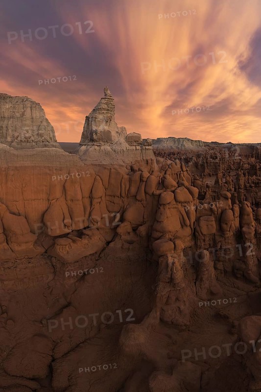A stunning view of unique sandstone formations under a dramatic sky in Goblin Valley State Park, Utah. The landscape showcases natural erosion's artistry