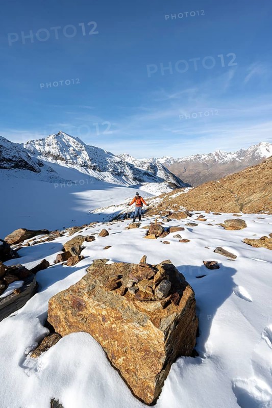 Mountaineer on a hiking trail with snow, descent from Ramoljoch at Spiegelferner, autumnal mountain landscape, mountain panorama, Ötztal Alps, Tyrol, Austria