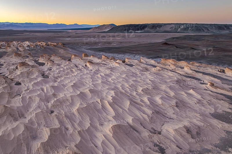 Stunning view of the pumice field in Catamarca, Argentina, highlighted by the soft light of sunrise. The landscape features unique rock formations and vast plains