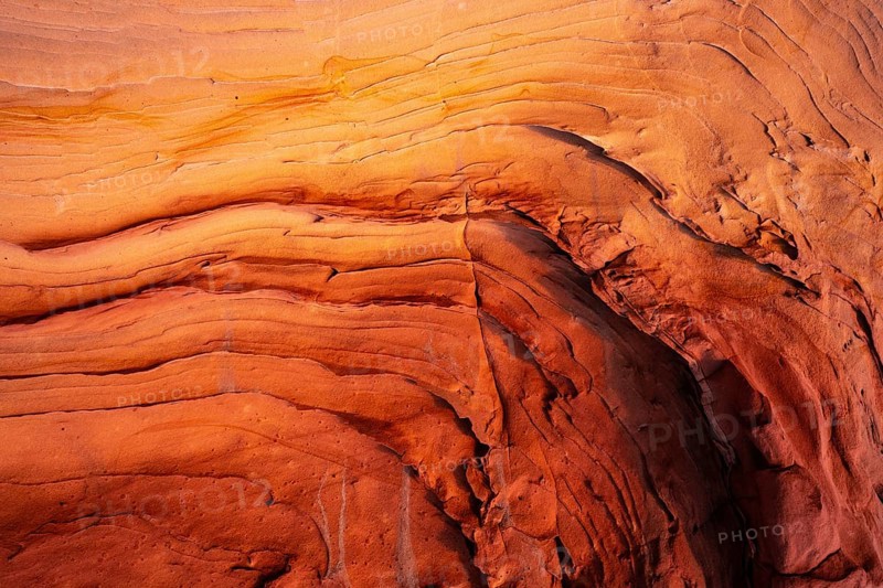 Close-up of textured red rock surfaces showing natural lines and curves, emphasizing the geological beauty and vibrant colors