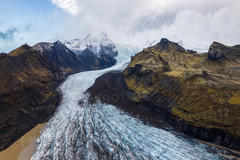 Stunning aerial capture of Vatnajökull Glacier winding through the rugged mountains of Vatnajökull National Park in Iceland, showcasing the icy expanse and raw, natural beauty