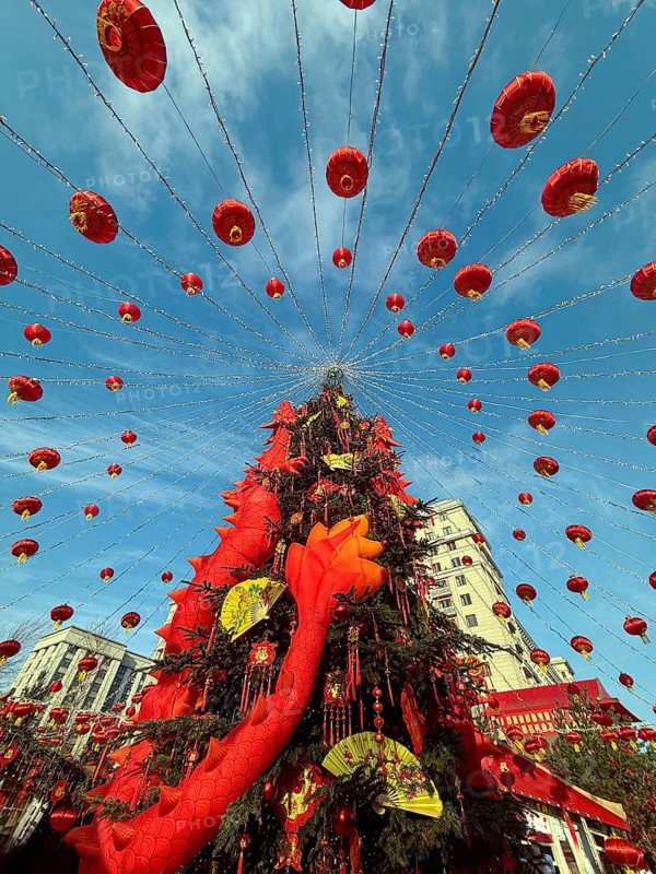 Vibrant Chinese New Year decorations adorn the streets with red lanterns and festive elements, creating a stunning and joyful atmosphere under a bright blue sky