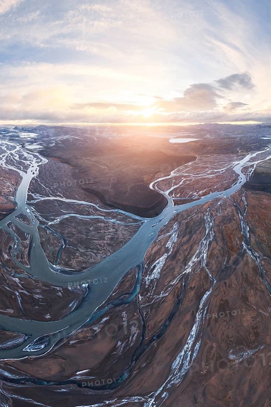 Breathtaking aerial view of meandering rivers in Iceland's Highlands, capturing the dramatic landscape at sunrise. Stunning natural patterns and earthy tones are highlighted