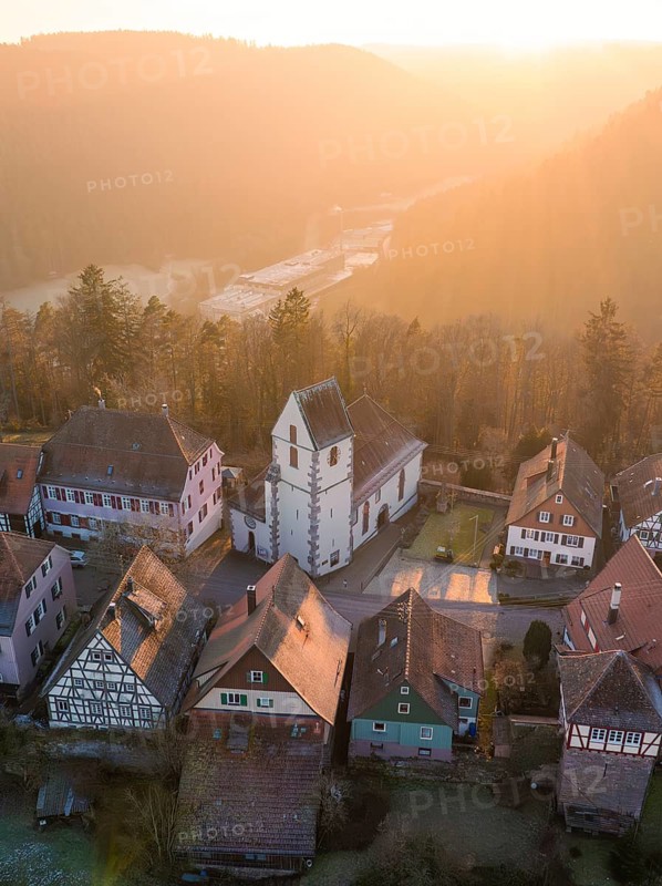 Half-timbered houses and a church in warm sunset light look idyllic and peaceful, Zavelstein, Calw district, Black Forest, Germany