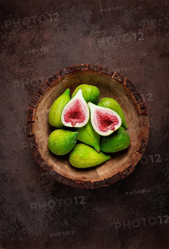 Fresh green figs, in a wooden plate, top view, close-up, no people