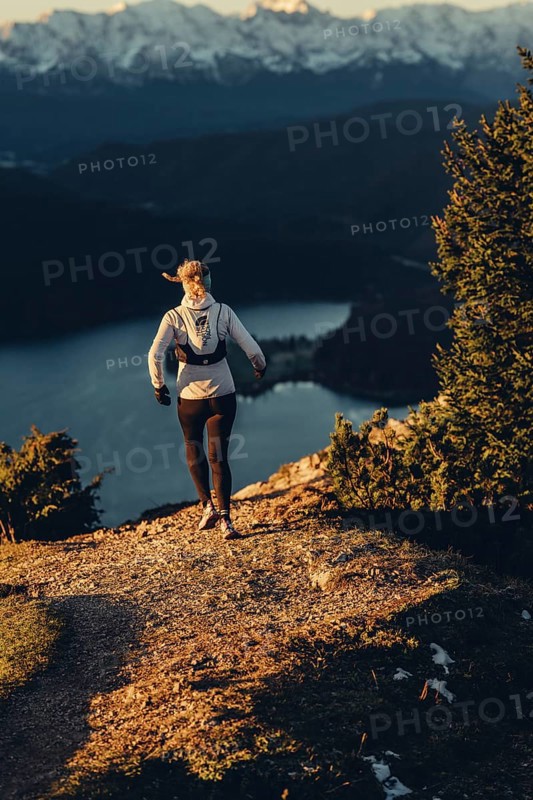 Trail running in autumn on the Jochberg on Lake Walchensee against the wonderful backdrop of the Alps, Bavaria, Germany