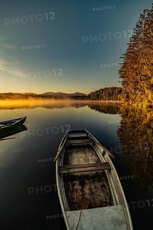 Boats in the autumnal Schmutter Weiher in the Allgäu near the municipalities of Halblech, Roßhaupten and Lechbruck in Ostallgäu in the foothills of the Alps