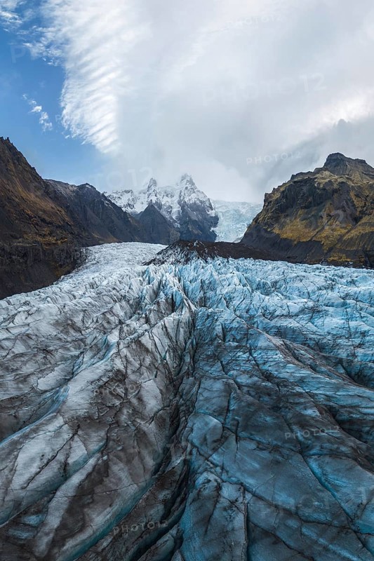 Stunning view of the expansive Vatnajökull Glacier, nestled within the rugged landscapes of Vatnajökull National Park in Iceland, showcasing intricate ice formations under a dramatic sky