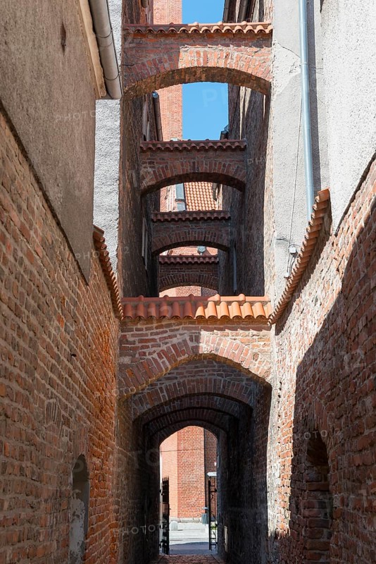 A narrow, arched passageway made of bricks with historical flair, 13th century church path, Elblag, Elbing, Warminsko-Mazurskie Voivodeship, Warminsko-Mazurskie, Poland
