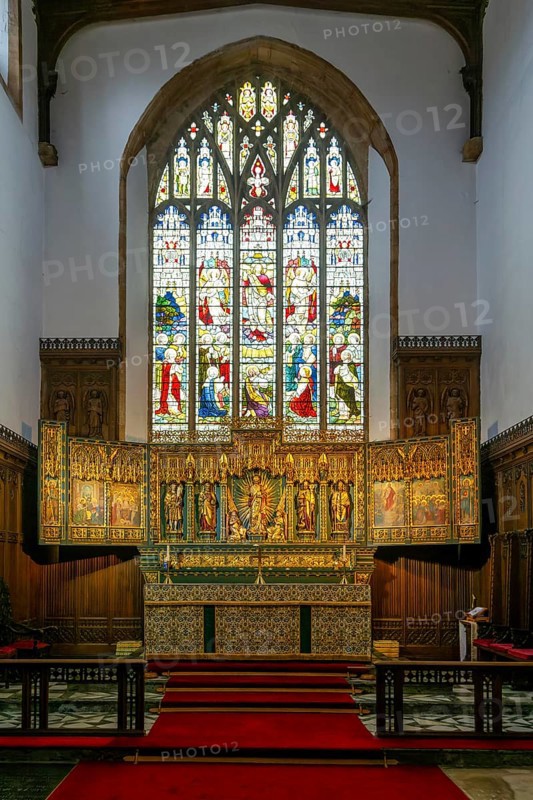 Stained glass east window, elaborately carved gilt altar reredos screen 1938, church of Saint John the Baptist, Peterborough, Cambridgeshire, England, UK