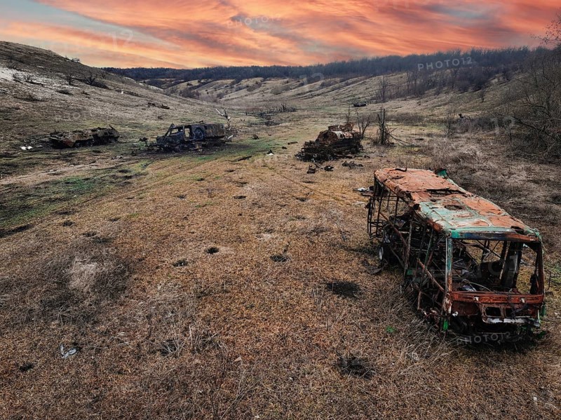 From above, this image captures the harsh reality of war in Ukraine, showing several burned out vehicles scattered across a desolate landscape