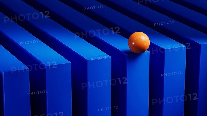 An orange sphere balances on blue geometric forms, creating a vibrant contrast against the structured backdrop. The 3D design enhances visual depth