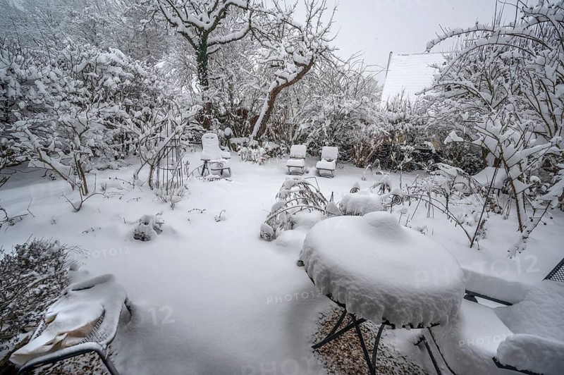 Snow-covered seats in a garden, Eckental, Middle Franconia, Bavaria, Germany