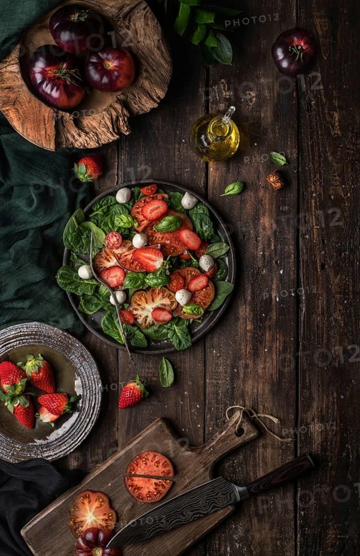 Healthy tomato and strawberry salad on a wooden rustic table