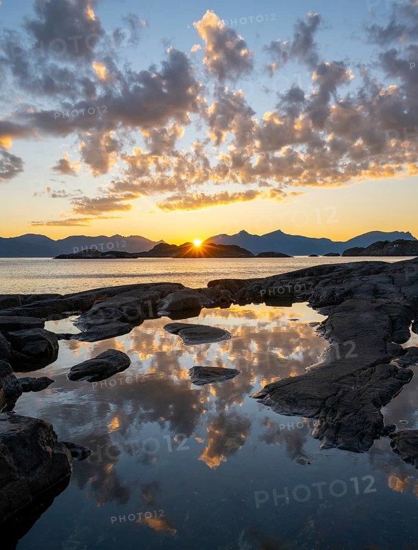 Clouds reflected in a small pond on a rocky coast, coastal landscape at sunset, Henningsvær, Lofoten, Nordland, Norway