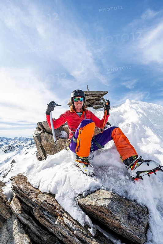 Happy mountaineer with ice axes and crampons on the summit of Piz Grialetsch in winter, Graubünden Haute Route, Albula Alps, Rhaetian Alps, Graubünden, Switzerland