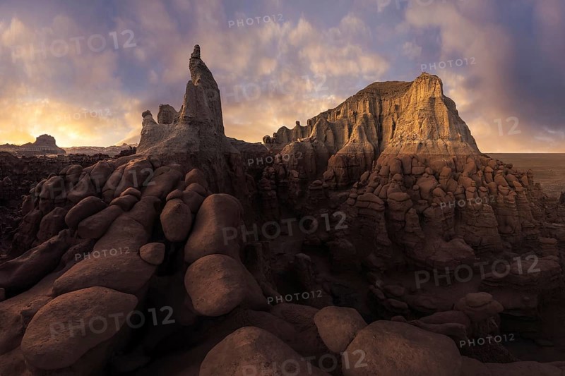 Stunning sandstone formations illuminated by soft sunlight in Goblin Valley State Park, Utah. The unique rock structures create a dramatic natural landscape