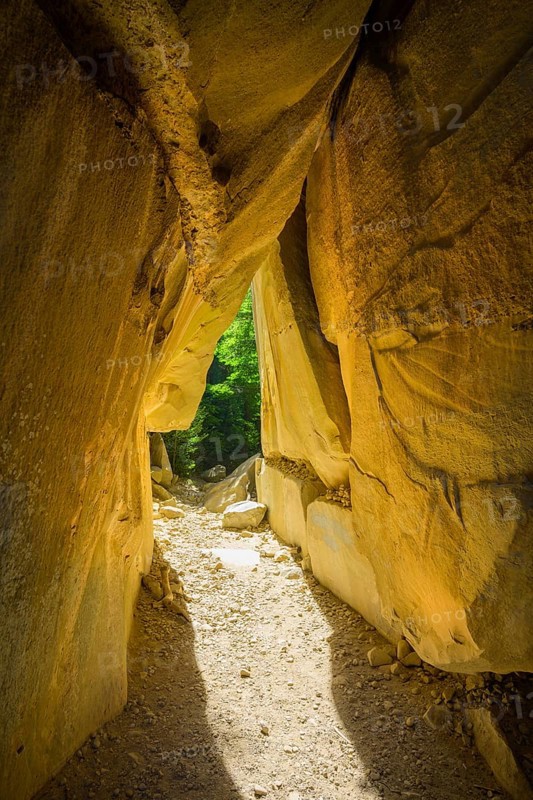Incidental sun illuminates the passage (Chambre du Roi) through the high rocks, hike through the sandstone labyrinth Grés d'Annot, Alpes-de-Haute-Provence, France