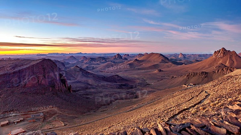 Vast desert landscape at sunset with mountain ranges on the horizon, The landscape of the Ahaggar Mountains in the Sahara in Algeria