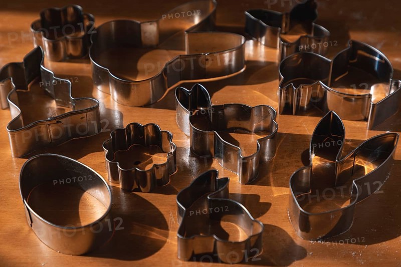 Different metal cookie cutters for Easter on a wooden surface