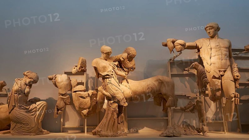 On the right, the god Apollo, west pediment of the Temple of Zeus, battle between lapiths and centaurs, ancient marble sculptures in a museum exhibition, showing fragmented figures from classical antiquity, Olympia Archaeological Museum, Ancient Olympia, Olympia, Peloponnese, Greece