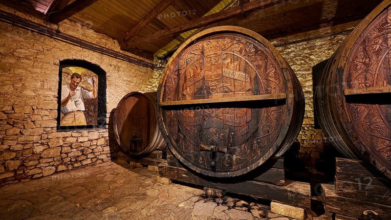 Wooden barrels in a historic wine cellar with painted wall decoration, Achaia Clauss winery, Patras, Peloponnese, Greece