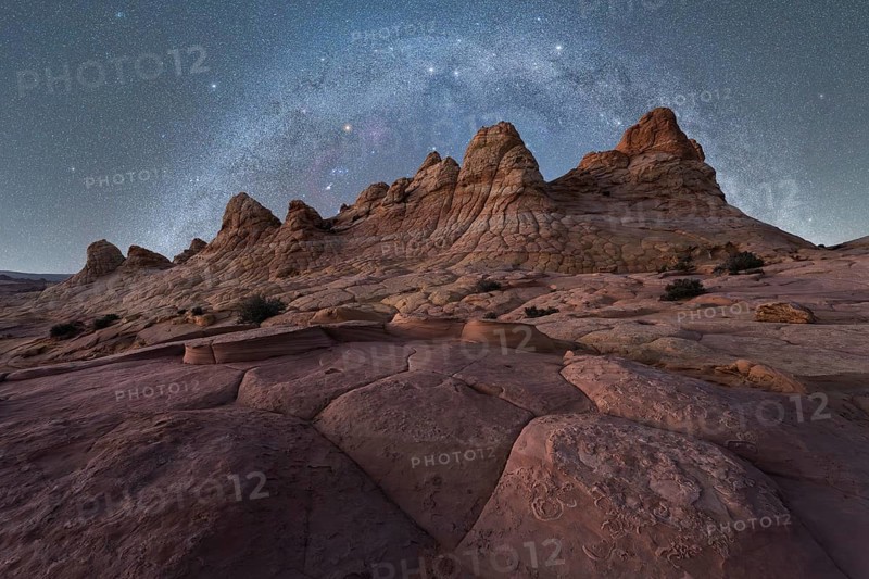 A breathtaking view of jagged rock formations under a vast, starry night sky, capturing the beauty of a remote desert landscape in Coyote Buttes, Arizona. Perfect for nature and travel enthusiasts