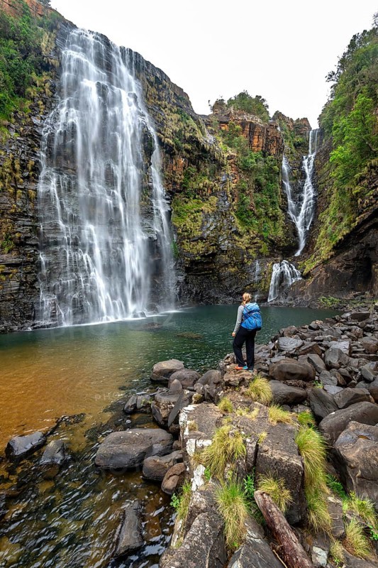 Young woman standing in front of a waterfall, Lisbon Falls, long exposure, near Graskop, Mpumalanga, South Africa