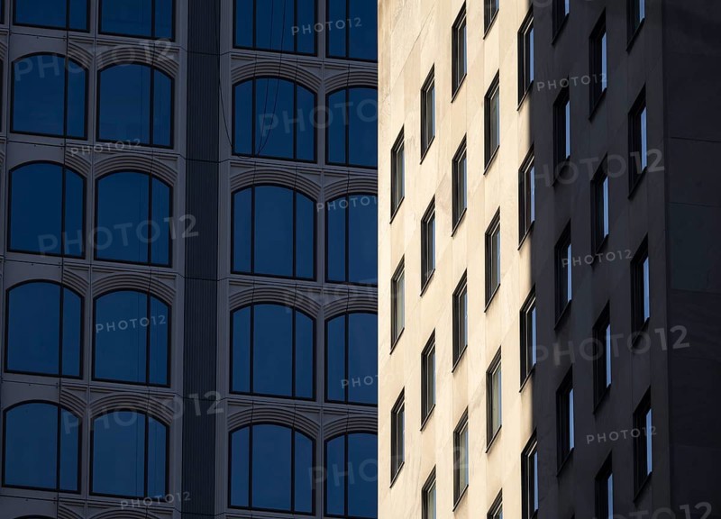 Architectural styles of two adjacent modern buildings in New York, capturing their unique facades under sunlight