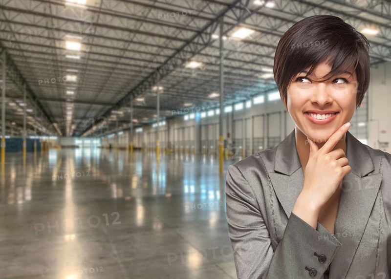 Thinking Mixed Race Businesswoman Standing in Empty Industrial Warehouse