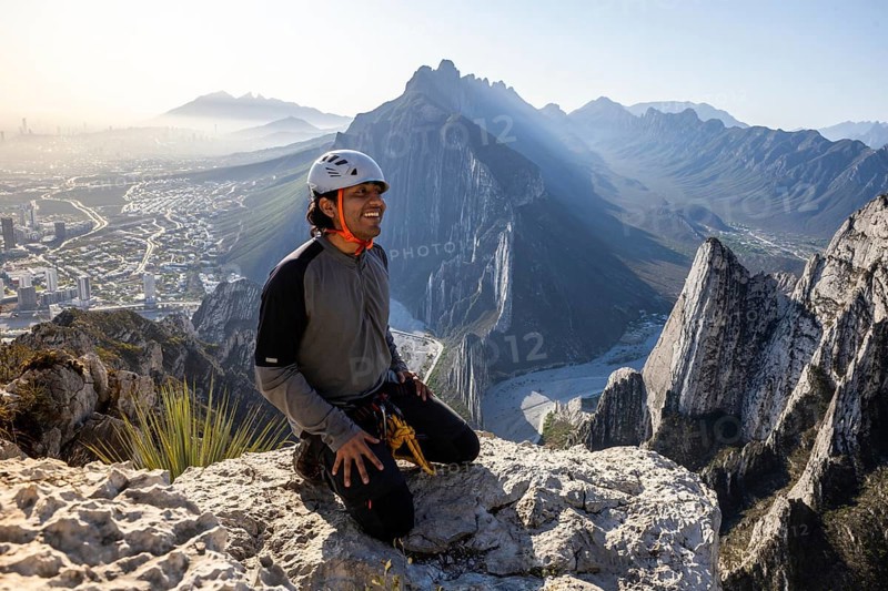 A man takes a break after practicing mountaineering and rappelling at Eagle's Nest in Monterrey, Mexico, enjoying the stunning views of the rugged mountainous landscape