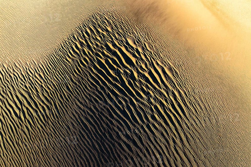 Explore the intricate textures of La Puna sand dunes at sunset. The golden hues and undulating patterns create a mesmerizing natural landscape formed by wind and time