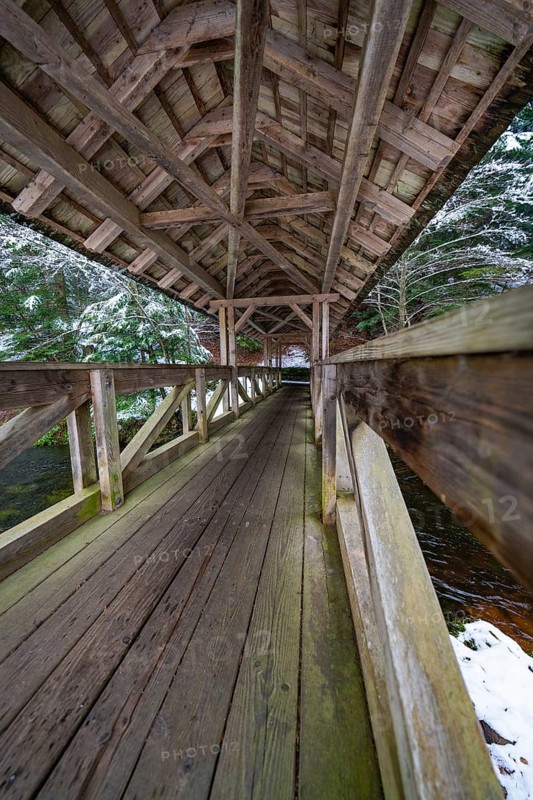 Interior view of a wooden bridge over a snow-covered forest path, Kälberbrücke, Enzklösterle, Calw district, Black Forest, Germany