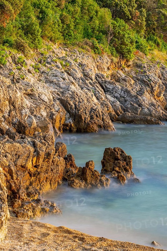 Crystal clear and turquoise water on the beach of Ustrine Bay on a sunny day at sunset on the island of Cres, long exposure, Croatia