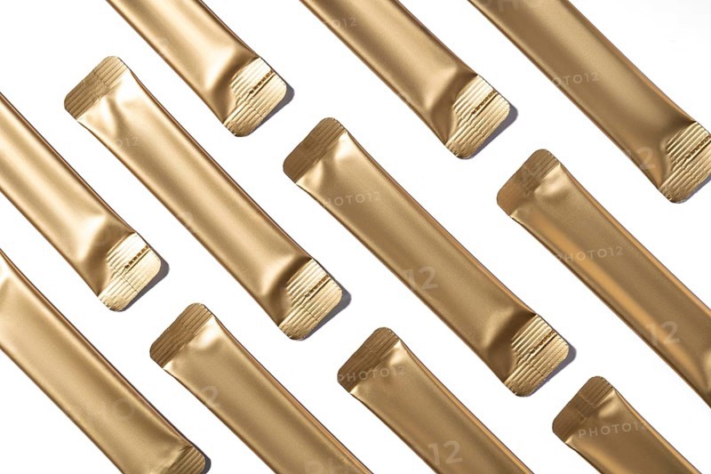 Top view of multiple golden collagen jelly sachets neatly arranged on a white background. These convenient, individually wrapped sachets are ideal for on-the-go collagen supplementation