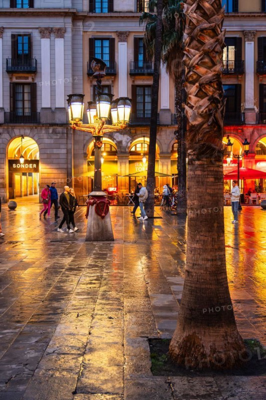 Nightlife at Plaça Reial, lanterns by Gaudi in the historic centre of Barcelona, Spain