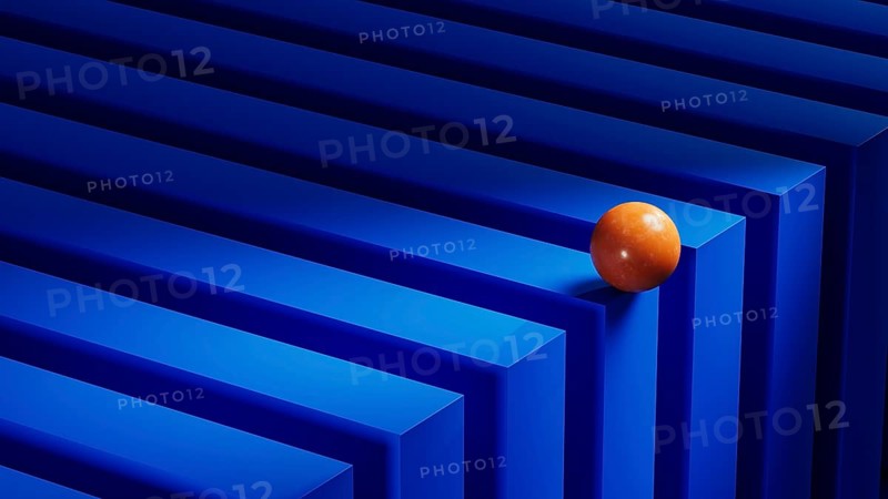 An orange sphere rests on a series of blue geometric shapes, creating an engaging abstract composition with vibrant colors and dynamic forms
