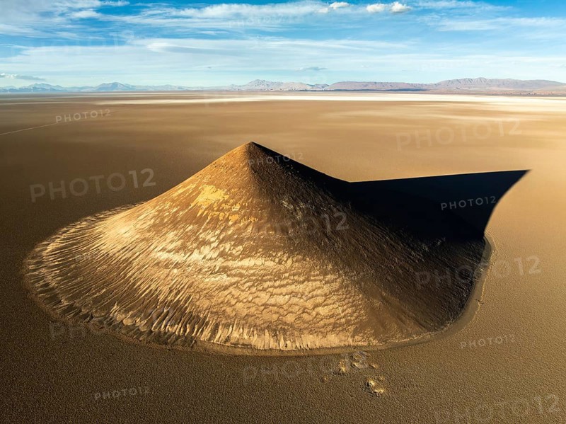 From above, this aerial shot captures the stunning Cono de Arita, a natural volcanic cone located in the remote puna region of Salta, Argentina