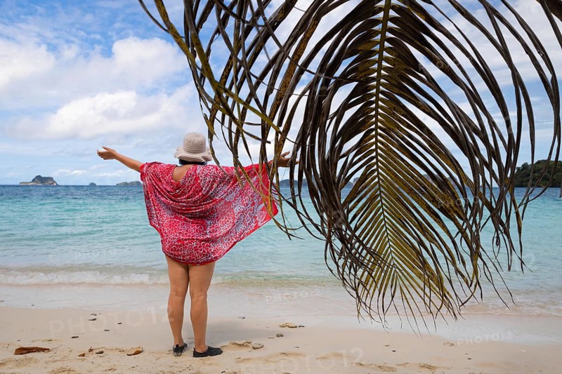 A woman enjoys the breathtaking panorama of the Raja Ampat Archipelago in West Papua, Indonesia The crystal-clear waters and lush landscapes offer a perfect ecotourism experience