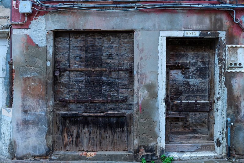Former grocery store, shop window and entrance door locked with wood, Venice, Veneto, Italy