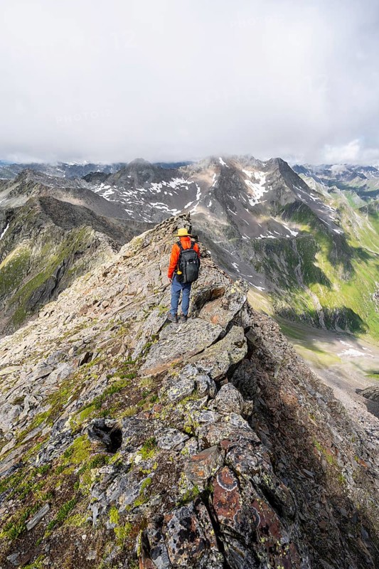 Mountaineer on a steep rocky ridge, on the summit of the Lasörling, Lasörling Group, Hohe Tauern National Park, East Tyrol, Tyrol, Austria