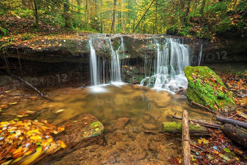 Waterfall in the course of the Strümpfelbach stream, colorful autumn leaves in the water, Strümpfelbachtal, near Backnang, Swabian-Franconian Forest nature park Park, Baden-Württemberg, Germany