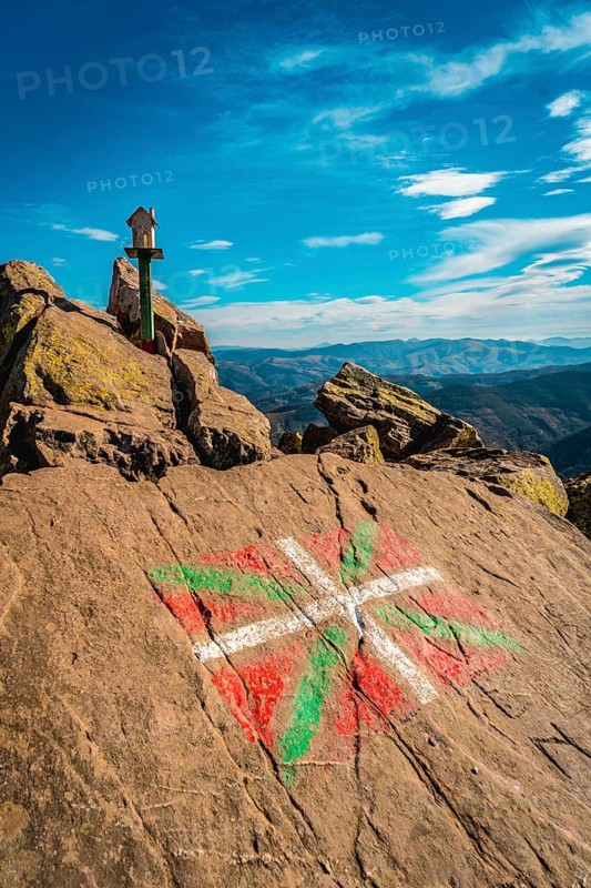 The flag of the Basque country and a figure of a house above Mount Adarra in Guipuzcoa one winter morning