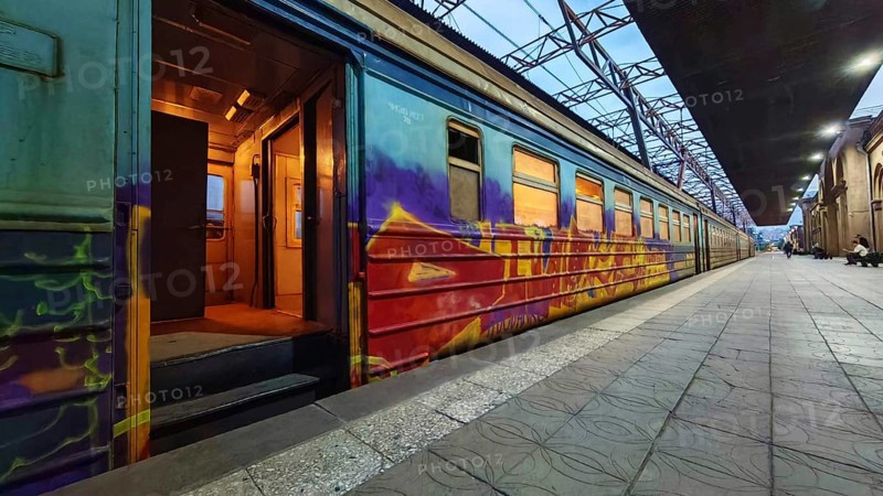 A graffiti-decorated train on the platform at dusk, Yerevan, Armenia