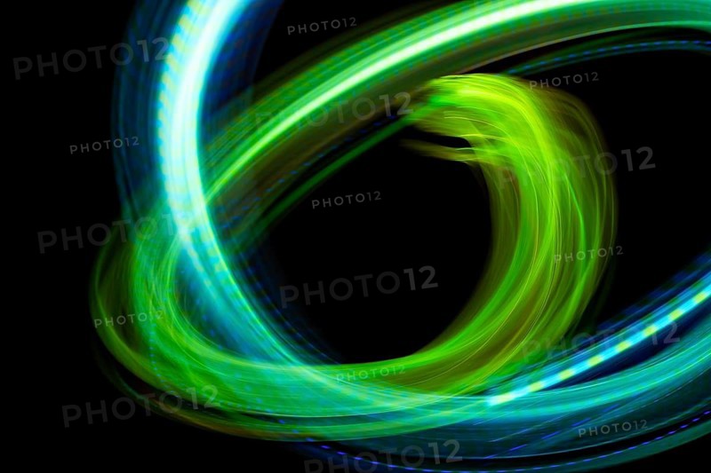 Dynamic abstract image showcasing swirling neon lights in vibrant green and blue hues against a stark black background, creating a sense of motion and energy through long exposure photography