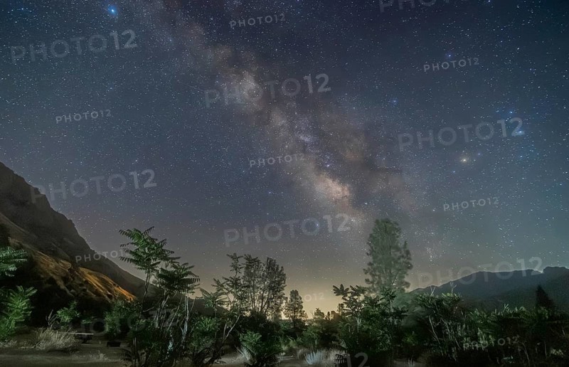 A breathtaking view of the Milky Way galaxy stretching above the serene landscape of Sequoia National Park, captured on a clear, star-filled night