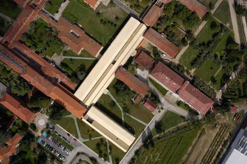 Captivating aerial shot of a hospital showcasing a harmonious blend of modern and historic architecture surrounded by lush green landscapes and pathways, highlighting urban planning and design